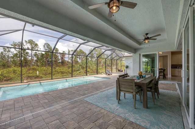 view of pool featuring ceiling fan, glass enclosure, and a patio area