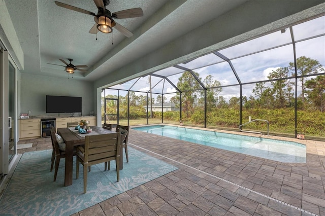 view of pool with glass enclosure, ceiling fan, and a patio area