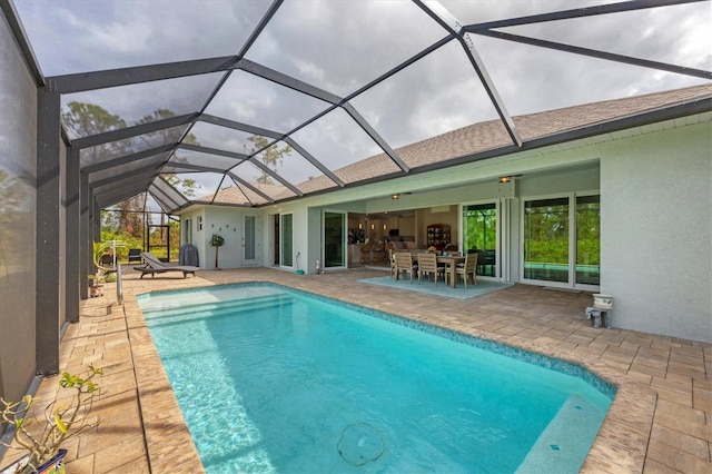 view of pool featuring glass enclosure and a patio