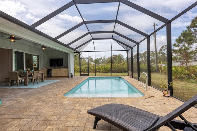 view of swimming pool featuring ceiling fan, glass enclosure, and a patio