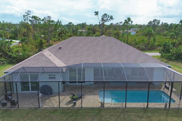 view of pool featuring glass enclosure and a patio area