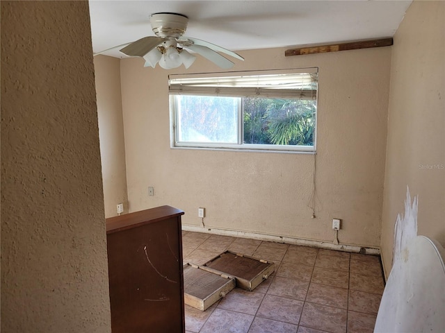 tiled empty room featuring ceiling fan