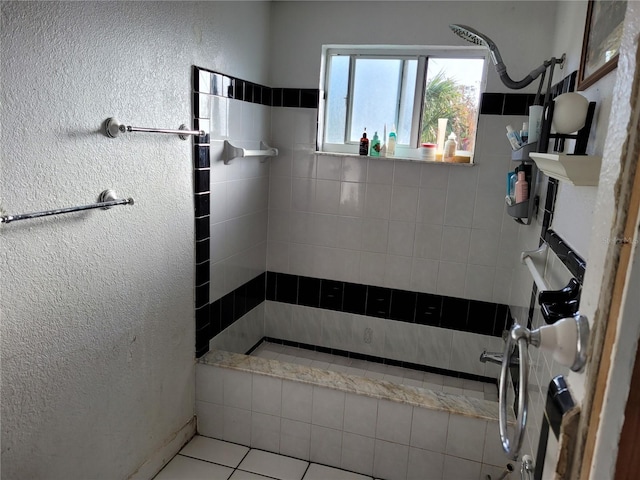 bathroom with tile patterned flooring and a tile shower