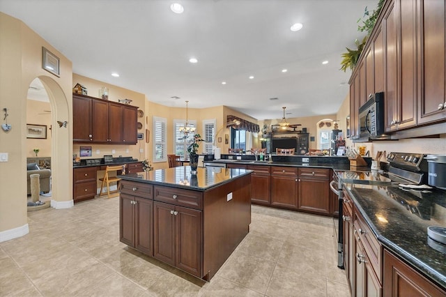 kitchen featuring pendant lighting, stainless steel electric range oven, dark stone counters, and a center island