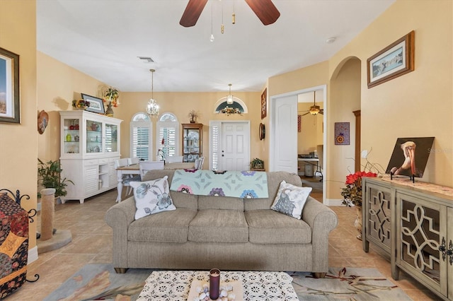 living room with ceiling fan with notable chandelier