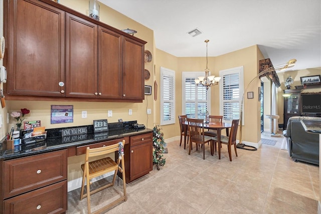 kitchen with dark stone countertops, a chandelier, light tile patterned floors, and hanging light fixtures