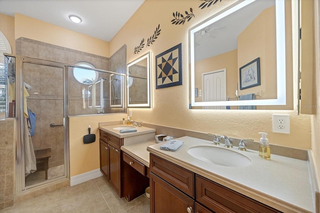 bathroom with an enclosed shower, vanity, and tile patterned floors