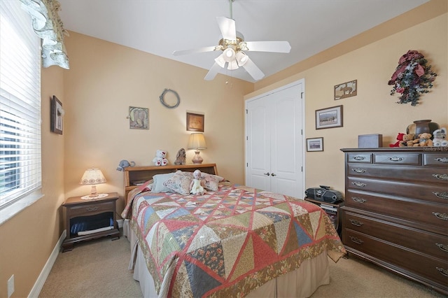 carpeted bedroom with ceiling fan and a closet