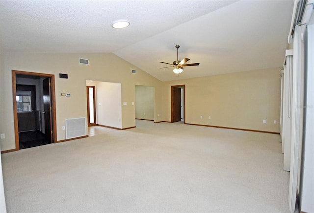 carpeted spare room with a textured ceiling, lofted ceiling, and ceiling fan