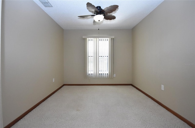 empty room with a textured ceiling, light carpet, and ceiling fan