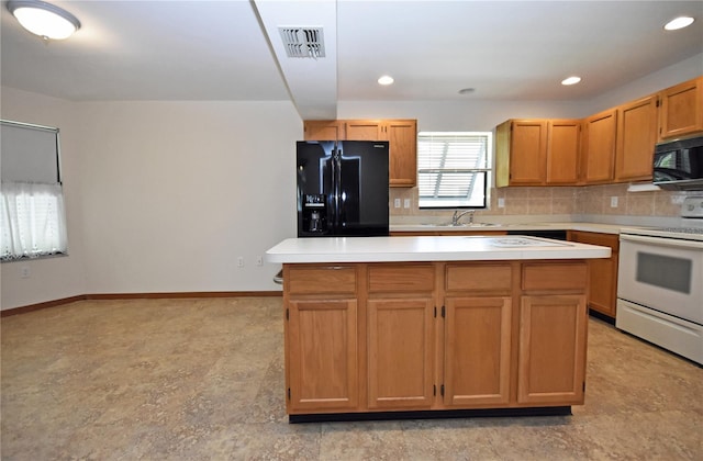 kitchen featuring black appliances, a kitchen island, backsplash, and sink