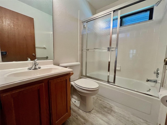 full bathroom with toilet, combined bath / shower with glass door, vanity, and hardwood / wood-style floors