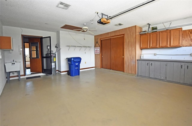 garage featuring electric water heater, ceiling fan, and a garage door opener