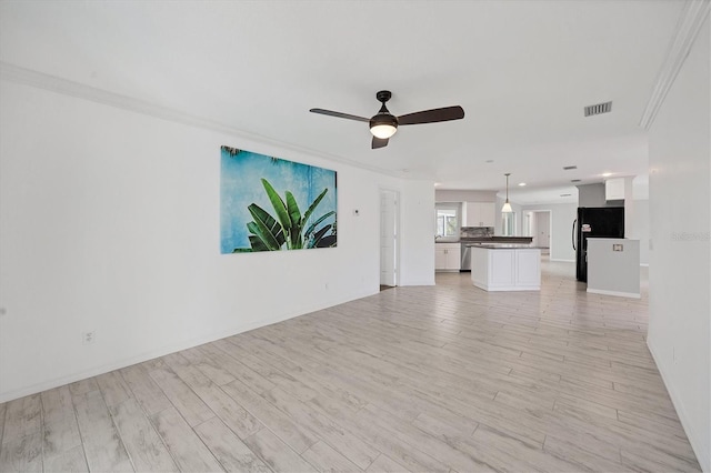 unfurnished living room featuring ceiling fan, crown molding, and light hardwood / wood-style floors