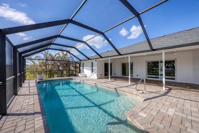 view of swimming pool with glass enclosure and a patio area