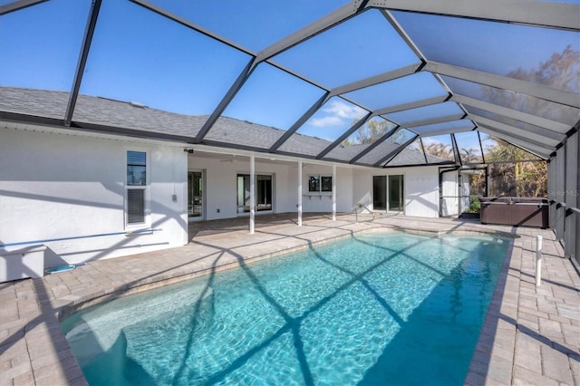 view of pool with ceiling fan, a hot tub, a patio, and a lanai