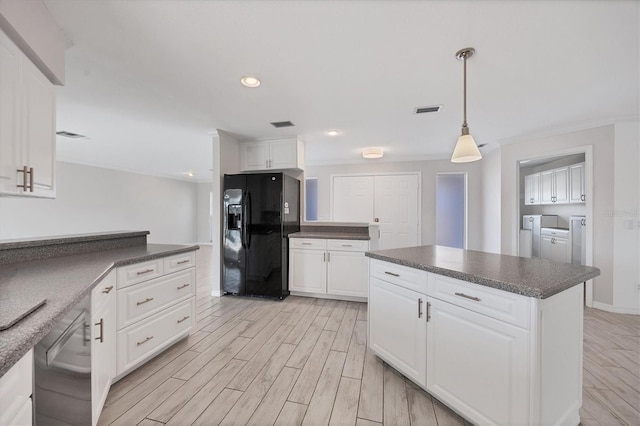 kitchen with dishwasher, black refrigerator with ice dispenser, washing machine and dryer, and white cabinets