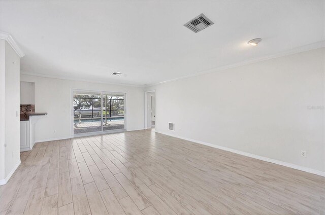 spare room featuring crown molding and light hardwood / wood-style floors