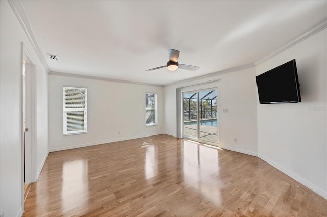 empty room with crown molding, ceiling fan, and light wood-type flooring