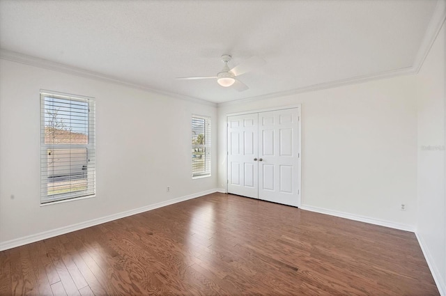 unfurnished bedroom featuring crown molding, dark hardwood / wood-style floors, and a closet