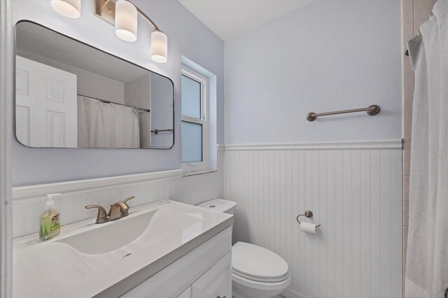 bathroom with vanity, curtained shower, and toilet