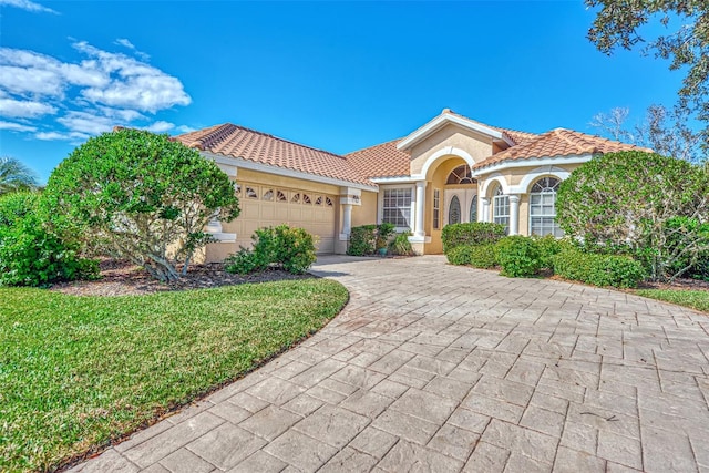 mediterranean / spanish-style house with a garage and a front yard