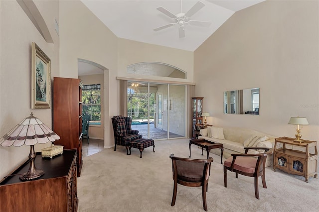 carpeted living room featuring high vaulted ceiling and ceiling fan