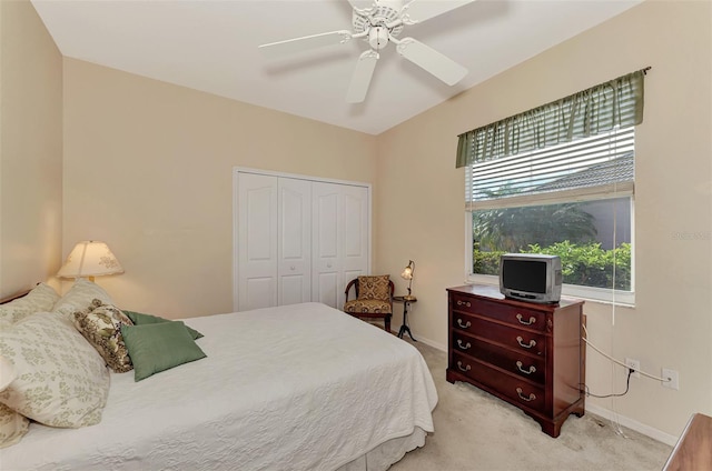 bedroom with light carpet, ceiling fan, multiple windows, and a closet