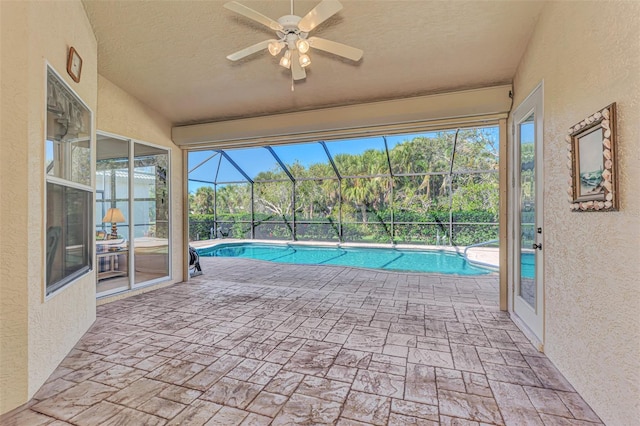 view of pool with ceiling fan, a patio, and a lanai