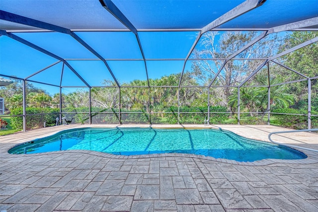 view of swimming pool featuring glass enclosure and a patio area