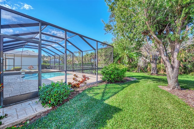 view of pool featuring a lawn and glass enclosure