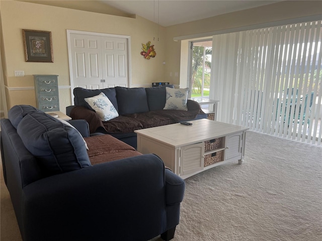 carpeted living room featuring vaulted ceiling