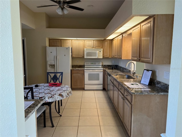 kitchen featuring light tile patterned floors, ceiling fan, white appliances, dark stone counters, and sink