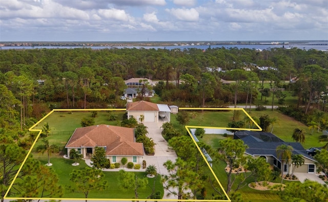 drone / aerial view featuring a water view and a view of trees