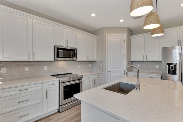 kitchen with stainless steel appliances, white cabinets, and sink