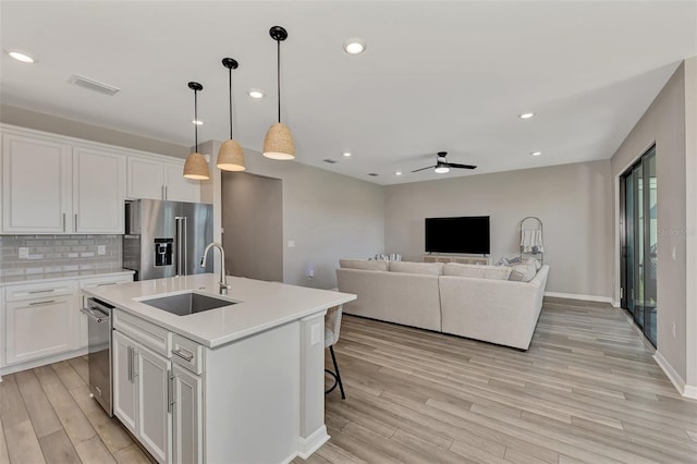 kitchen featuring light hardwood / wood-style floors, sink, an island with sink, white cabinets, and high end fridge