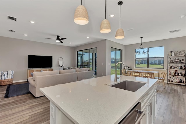 kitchen featuring hanging light fixtures, sink, a healthy amount of sunlight, and white cabinets