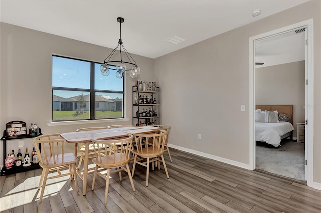 dining space featuring hardwood / wood-style floors and a notable chandelier