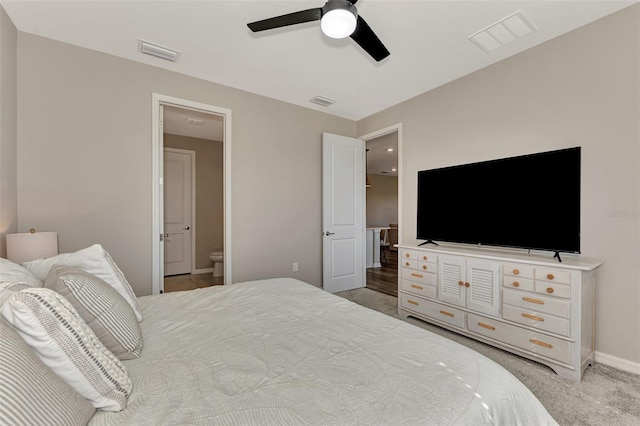 carpeted bedroom with ceiling fan and ensuite bathroom