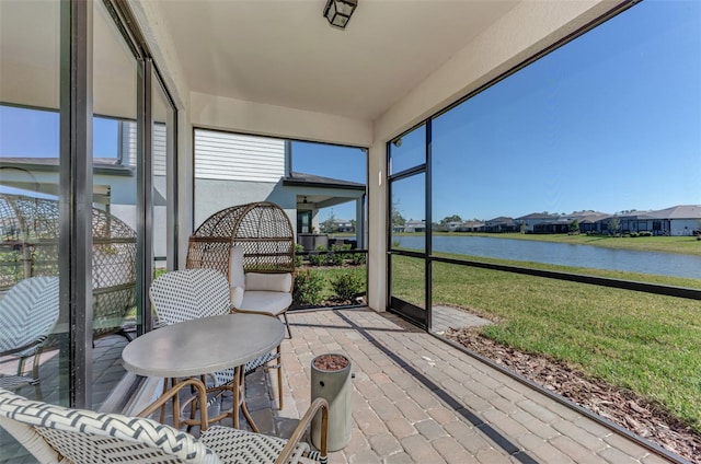 sunroom featuring a water view