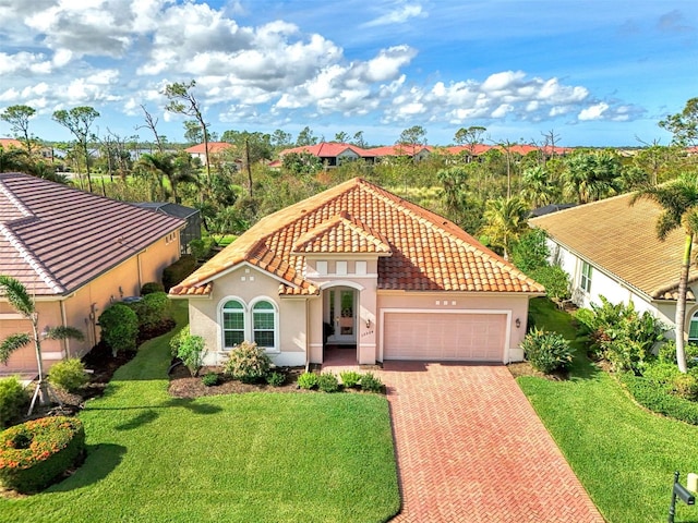 mediterranean / spanish-style house featuring a garage and a front lawn