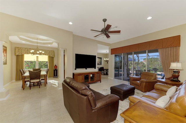 living room featuring ceiling fan with notable chandelier, a wealth of natural light, and light tile patterned flooring