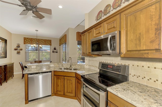 kitchen with backsplash, appliances with stainless steel finishes, light tile patterned floors, sink, and kitchen peninsula