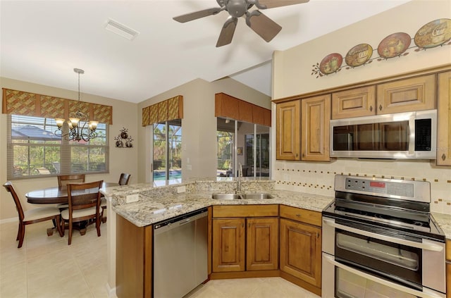 kitchen featuring light tile patterned flooring, stainless steel appliances, pendant lighting, decorative backsplash, and sink