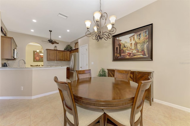 tiled dining space with ceiling fan with notable chandelier