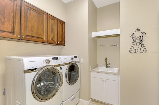 washroom with cabinets, sink, and washing machine and clothes dryer