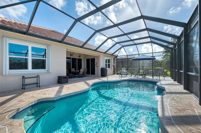 view of pool featuring glass enclosure and a patio area