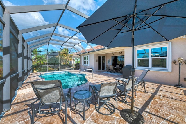 view of swimming pool featuring glass enclosure and a patio area