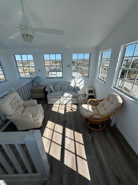 living room with hardwood / wood-style floors, ceiling fan, and lofted ceiling