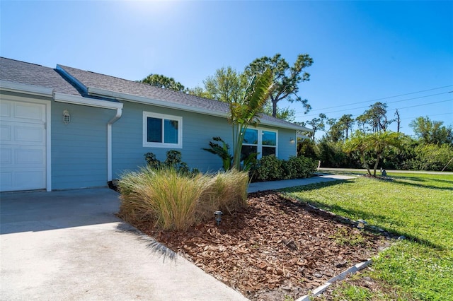 view of property exterior with a garage and a lawn